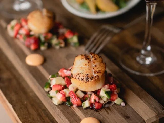 Scallops with fresh vegetables and a glass of wine.