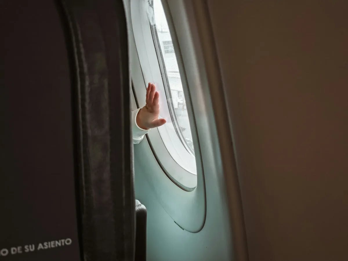 Baby's hand on an airplane's window.