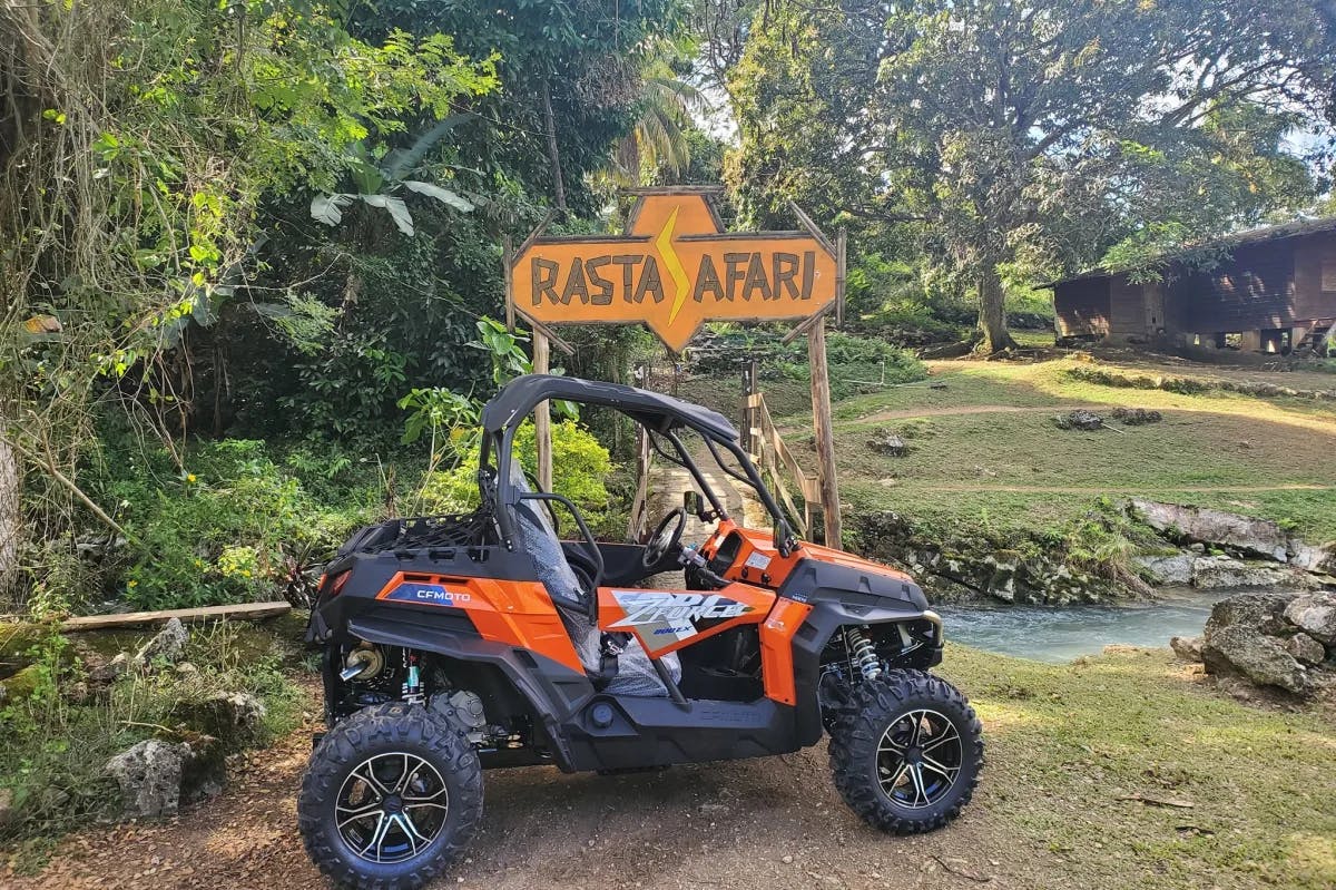 An ATV in front of a sign reading "Rasta Safari"