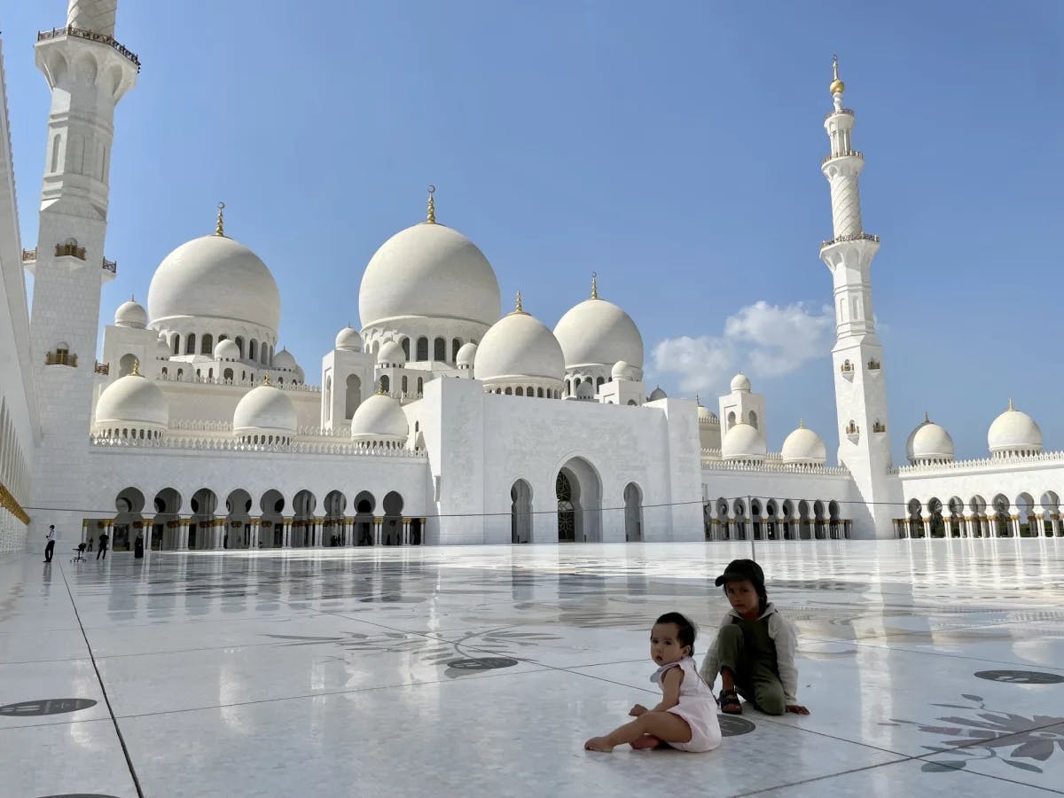 Two kids in a white mosque. 