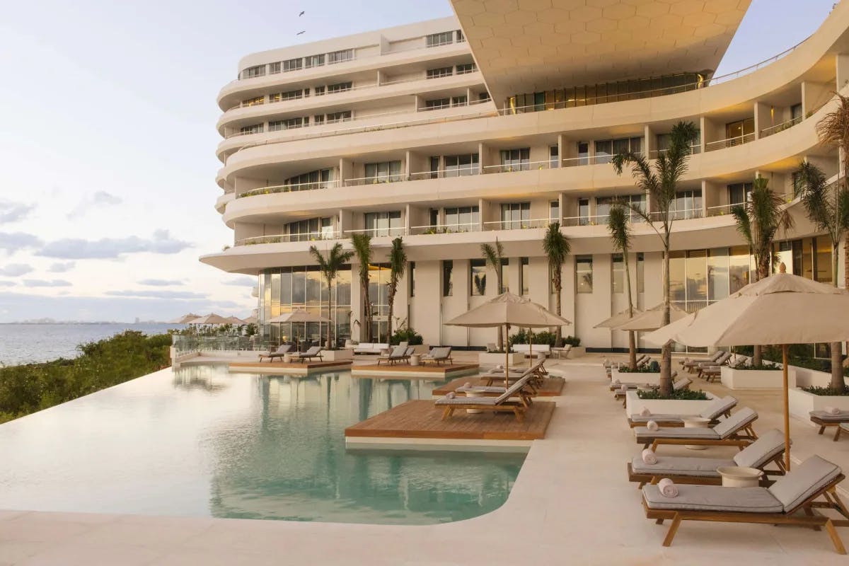 A sleek hotel pool deck overlooking the jungle and sea