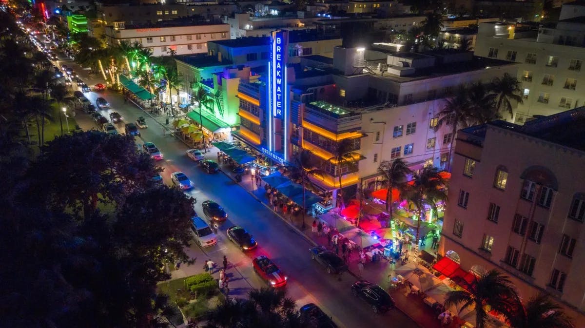 street in a beach town with multicolored lights emanating from neon signs at night