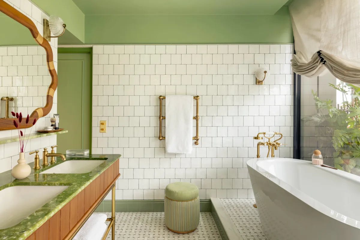 a fancy bathroom with green walls and a large white tub