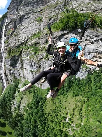 A couple paragliding down the side of a mountain