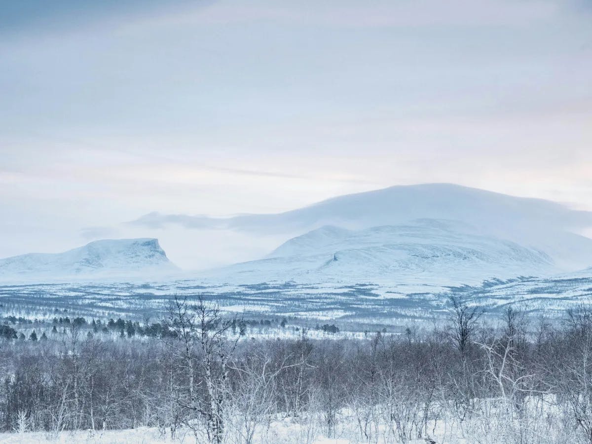 A snowy landscape with mountains in the distance