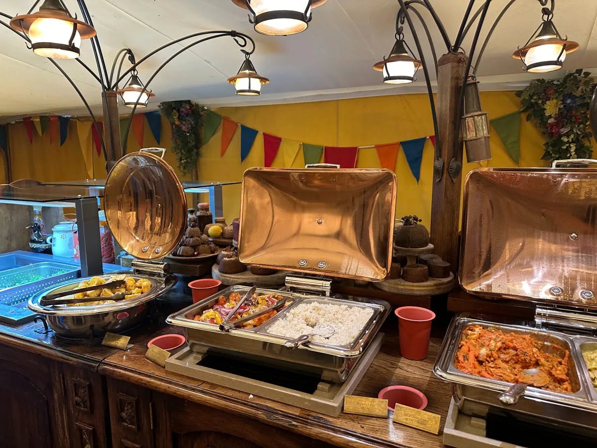 A buffet setup with various dishes and colorful decorations creates an inviting dining atmosphere.