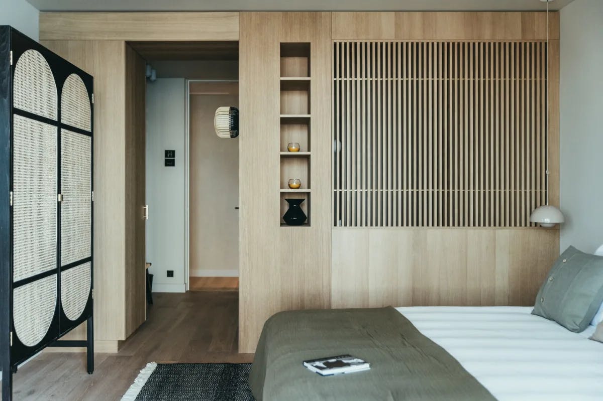 modern room featuring a bed and wood paneled wall with neutral colors