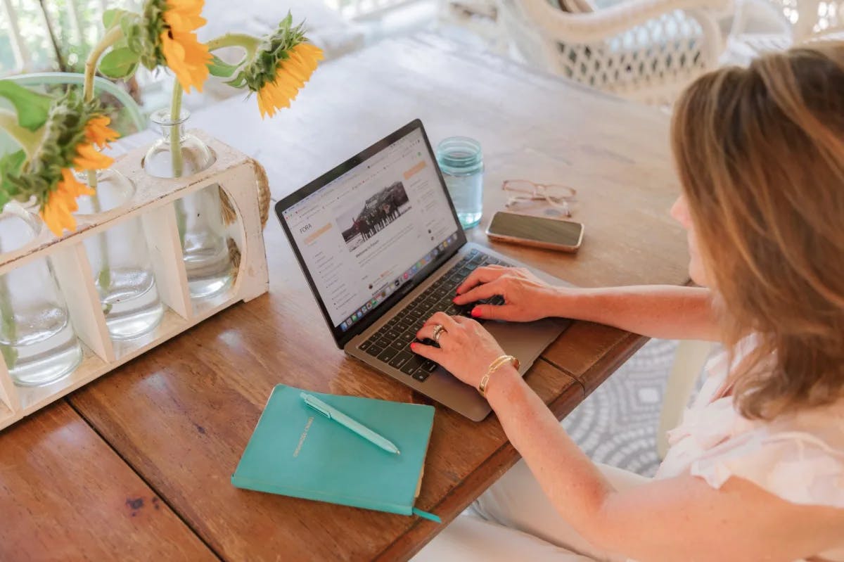 looking down on desk with computer and woman typing