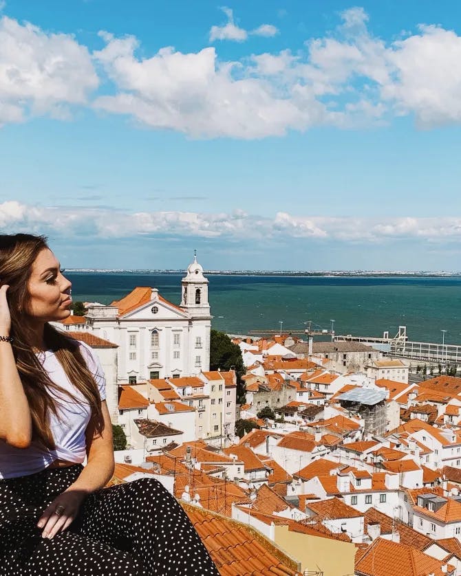 Looking at the beautiful views of Lisbon with terracotta rooftops and the sea in the background