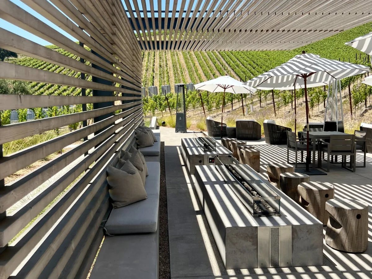 Outdoor sitting of a restaurant under a wooden shade. 