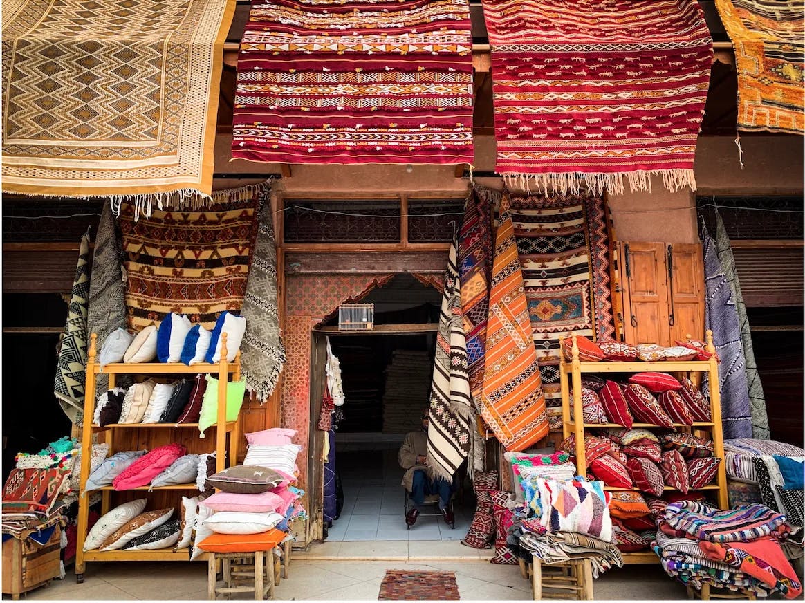 A shop selling colorful rugs and cushions.