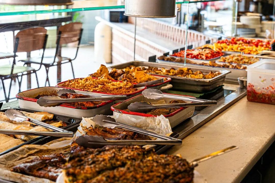 Platters of food line a table at sunlit restaurant Cacho.