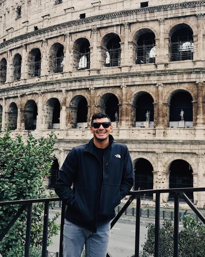 Travel advisor in black jacket posing in front of an ancient place 