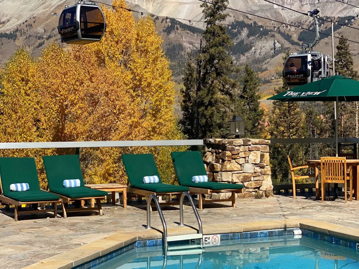 Outdoor sitting with pool, chairs and a gondola. 