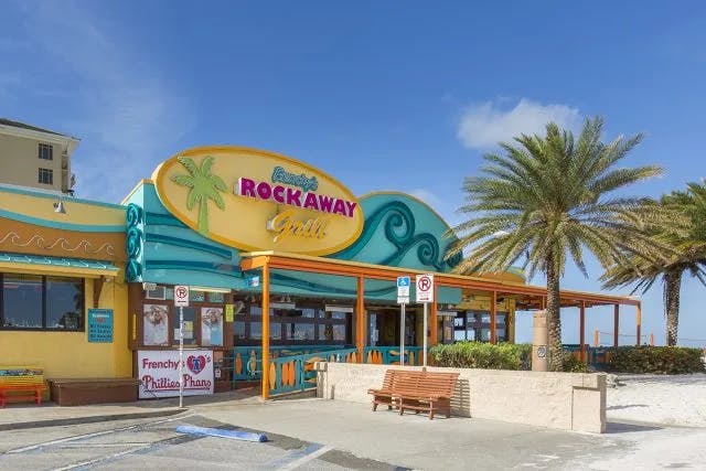 A restaurant sign reading "Rockaway Grill" taken from outside during daytime