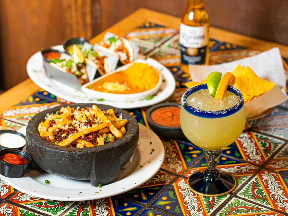 A picture of different kinds of food served on a table with cocktails. 