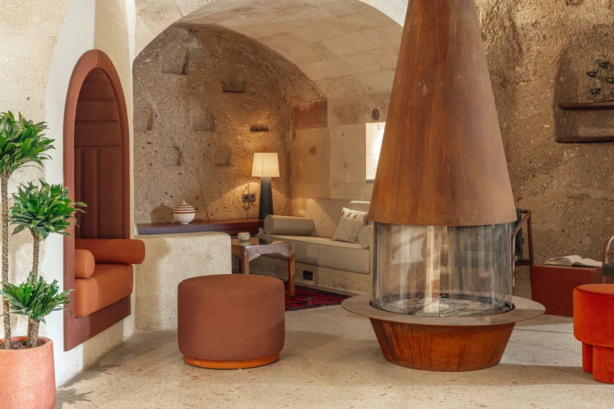 a modern conical fire place in a stone-walled hotel lobby