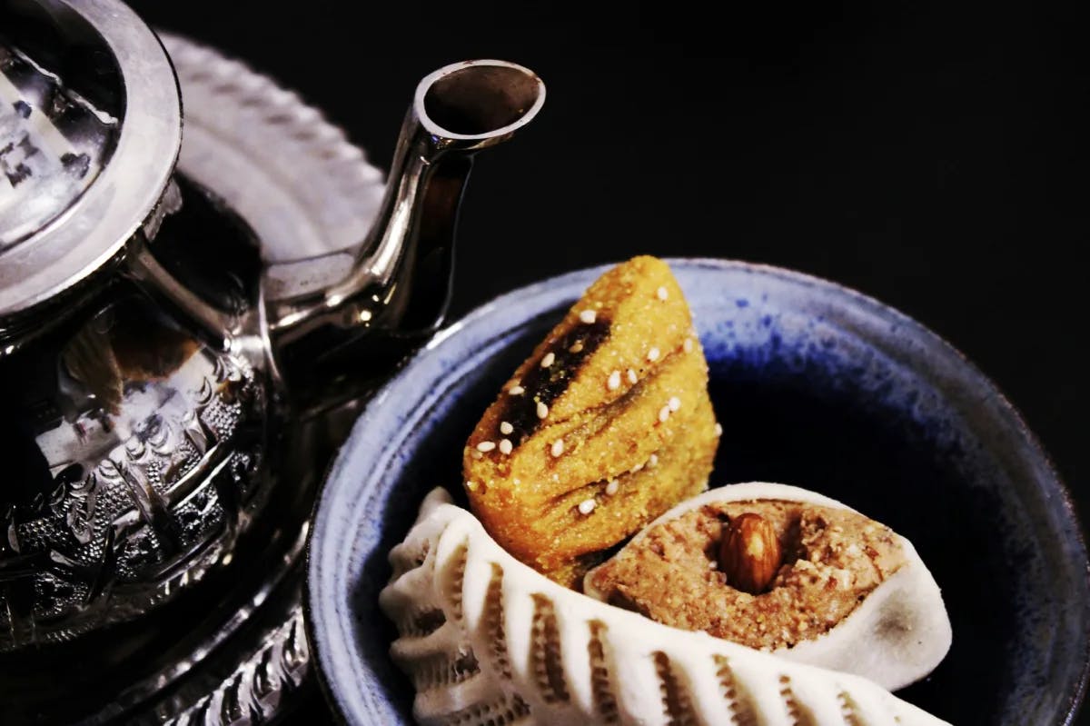 Pastries with a steel tea kettle.