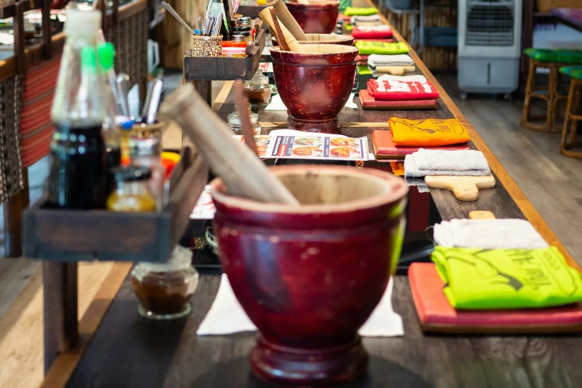 A long table with bowls on top to be used for a cooking class.