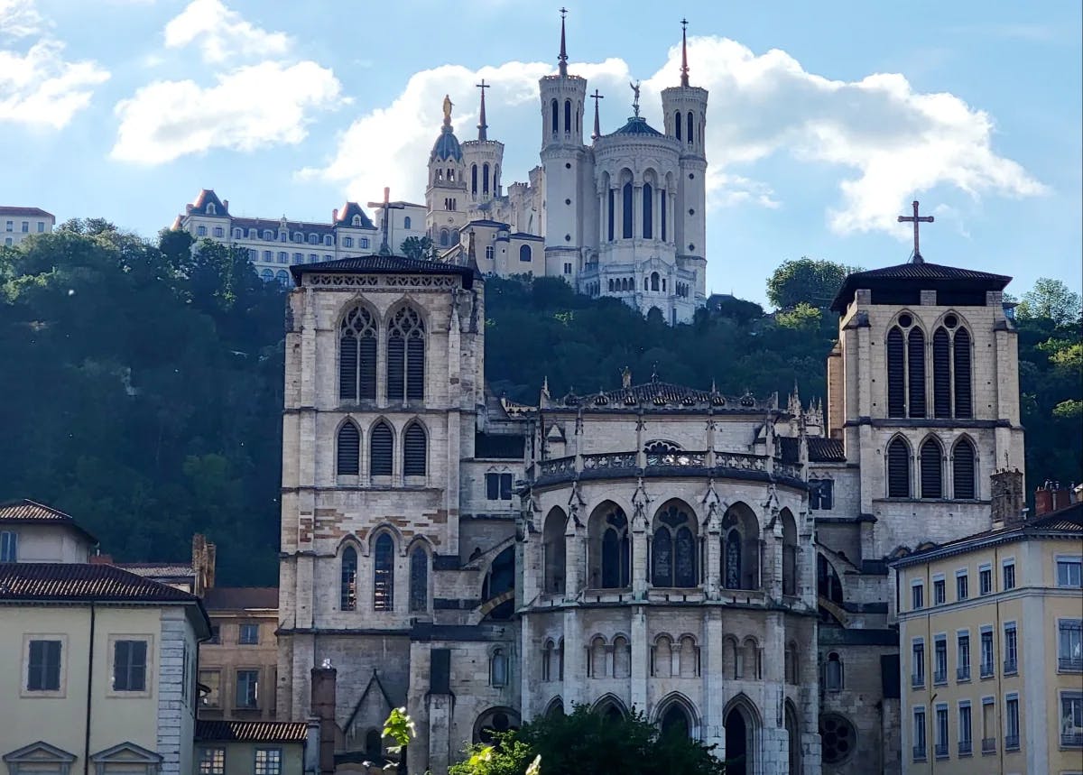 A view of Lyon churches and classic buildings on a hill side during the day time.