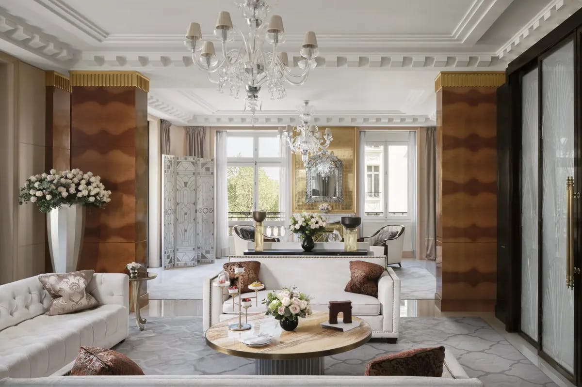 A sophisticated living room with posh white couches beneath a crystal chandelier