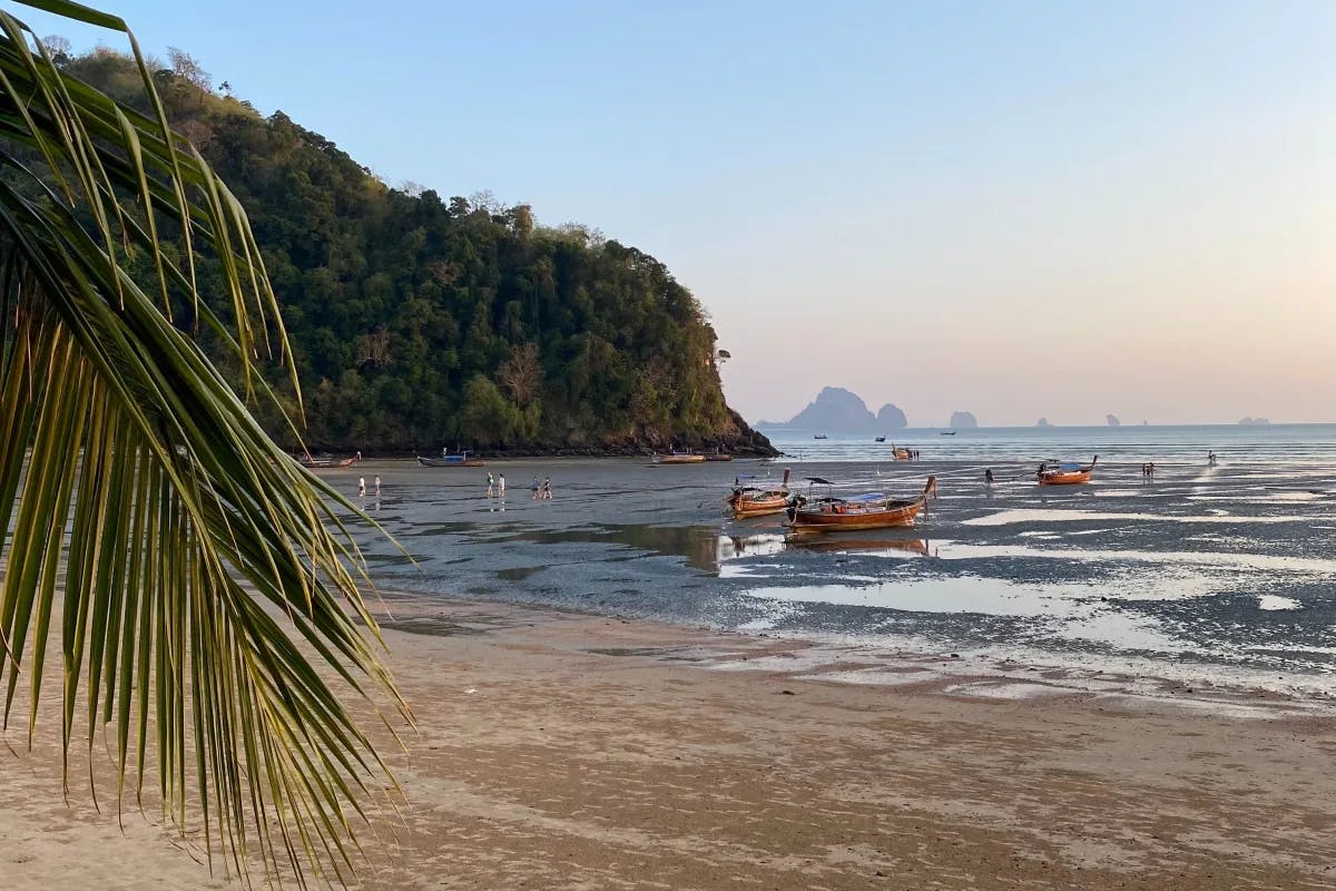 A beautiful island with boats on the water in Thailand. 