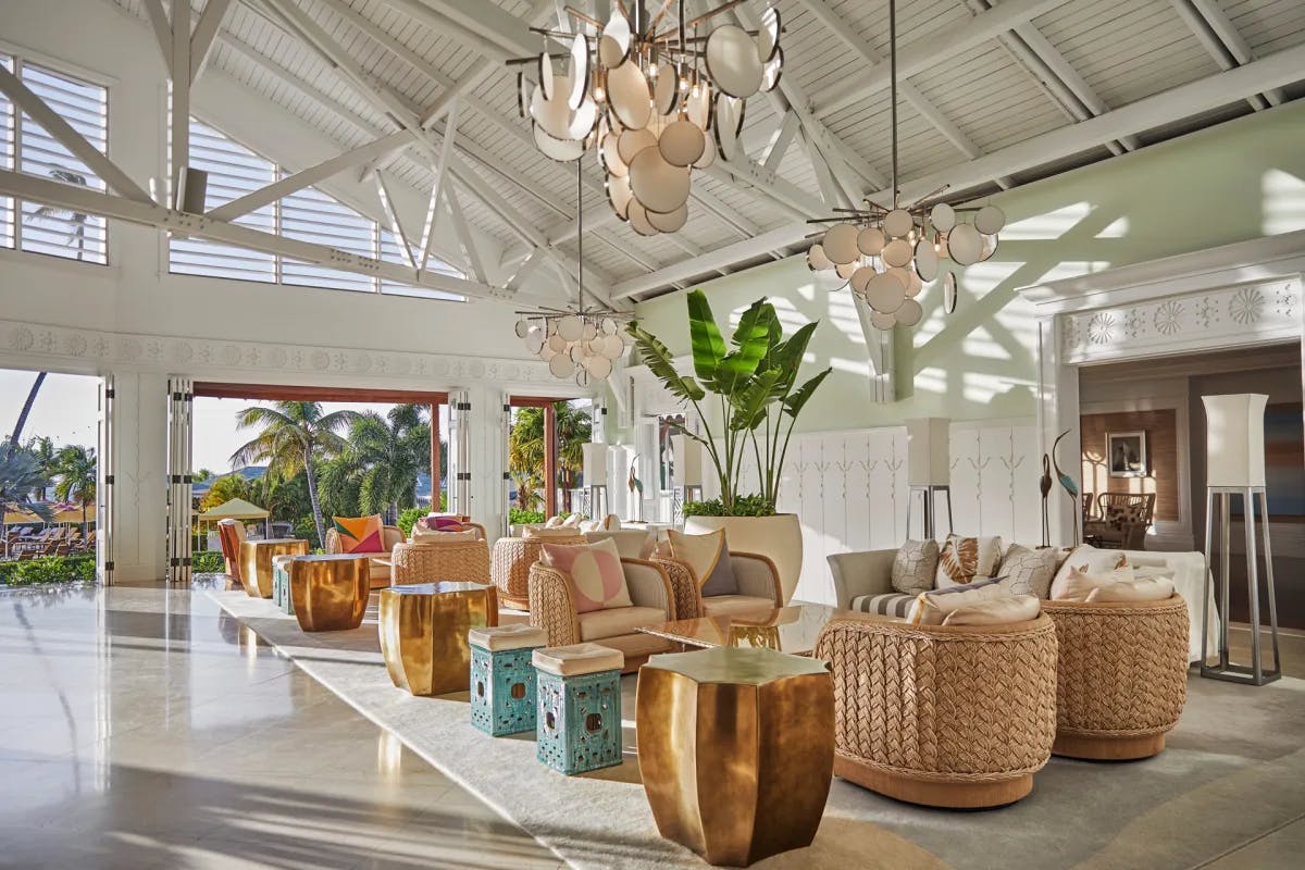 an airy seating area in a white room with towering ceilings and beachy decor