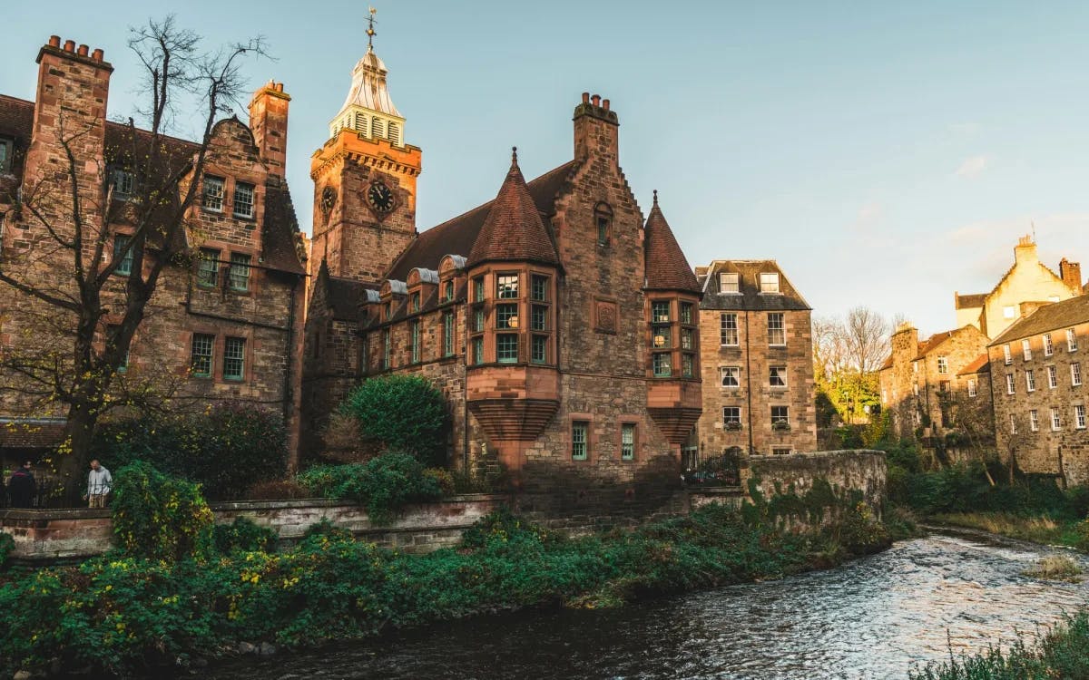 A brown medieval building on a riverbank.