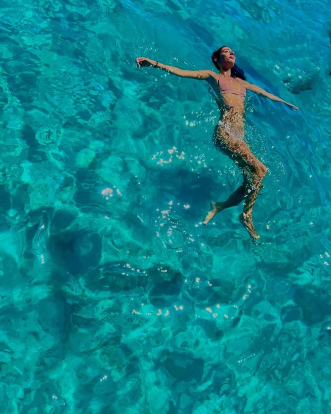 Camille seen from above floating in clear turquoise ocean water 