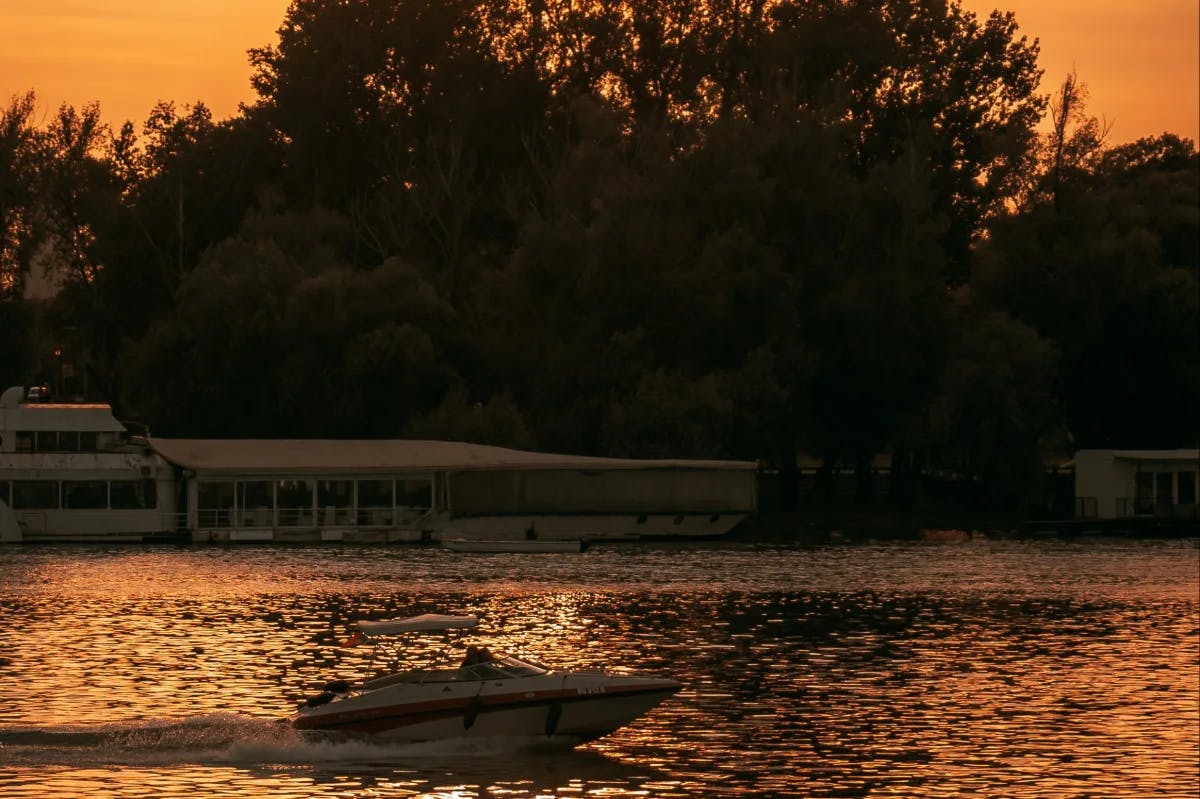 View of a lake with boat docks and a light house. 