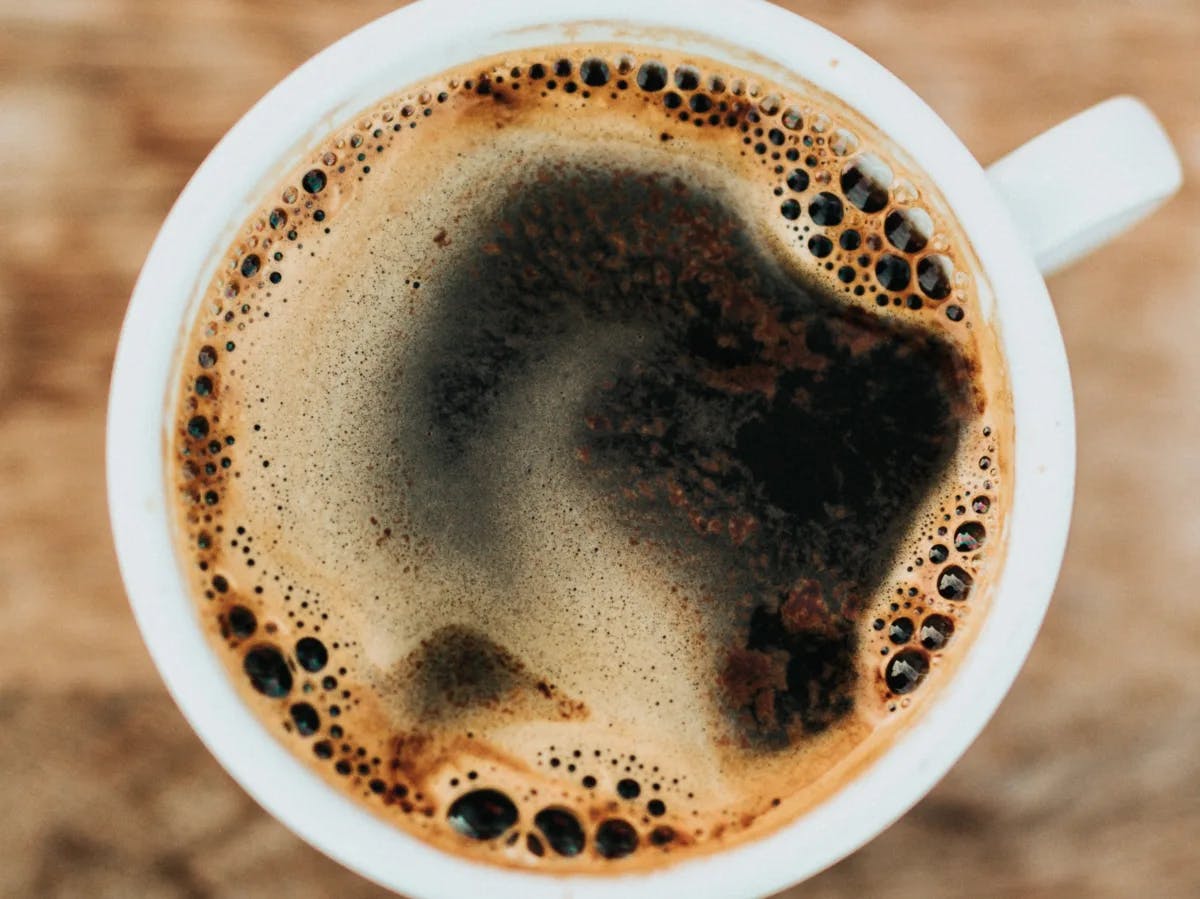 White mug filled with coffee on a wooden table