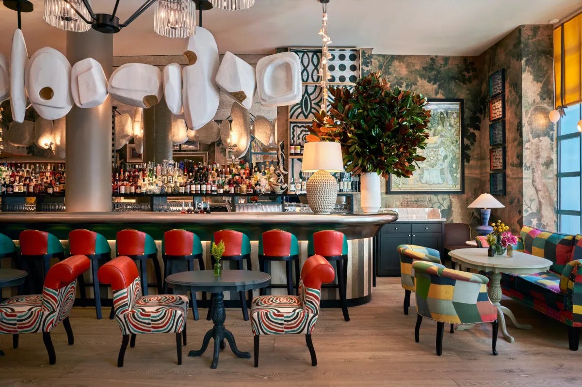 a chic restaurant with colorful upholstered chairs and funky, white geometric light fixtures