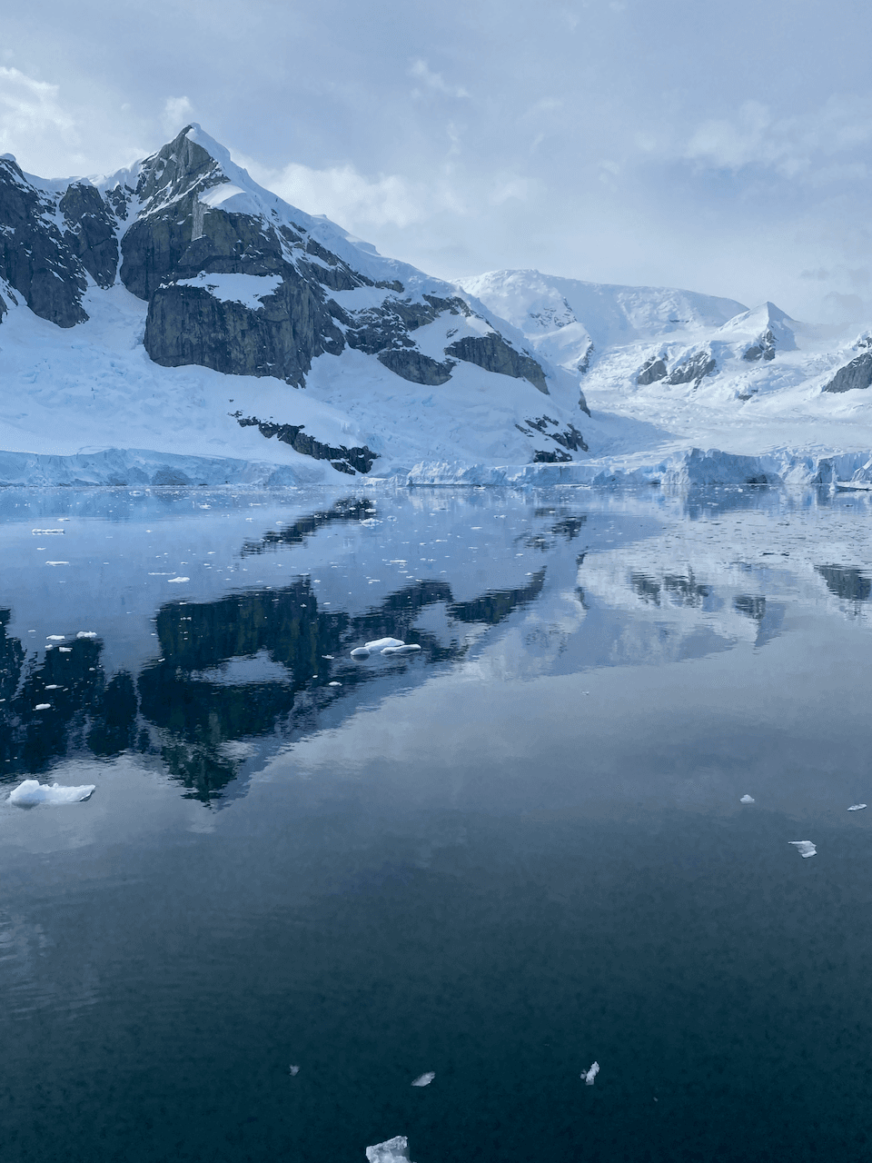 Ice covered mountains by the water.