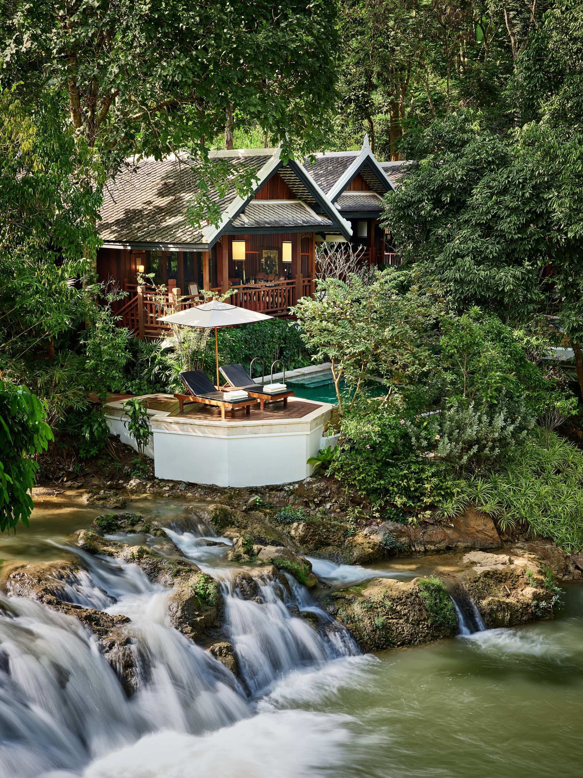 A water fall in a river next to a hotel building