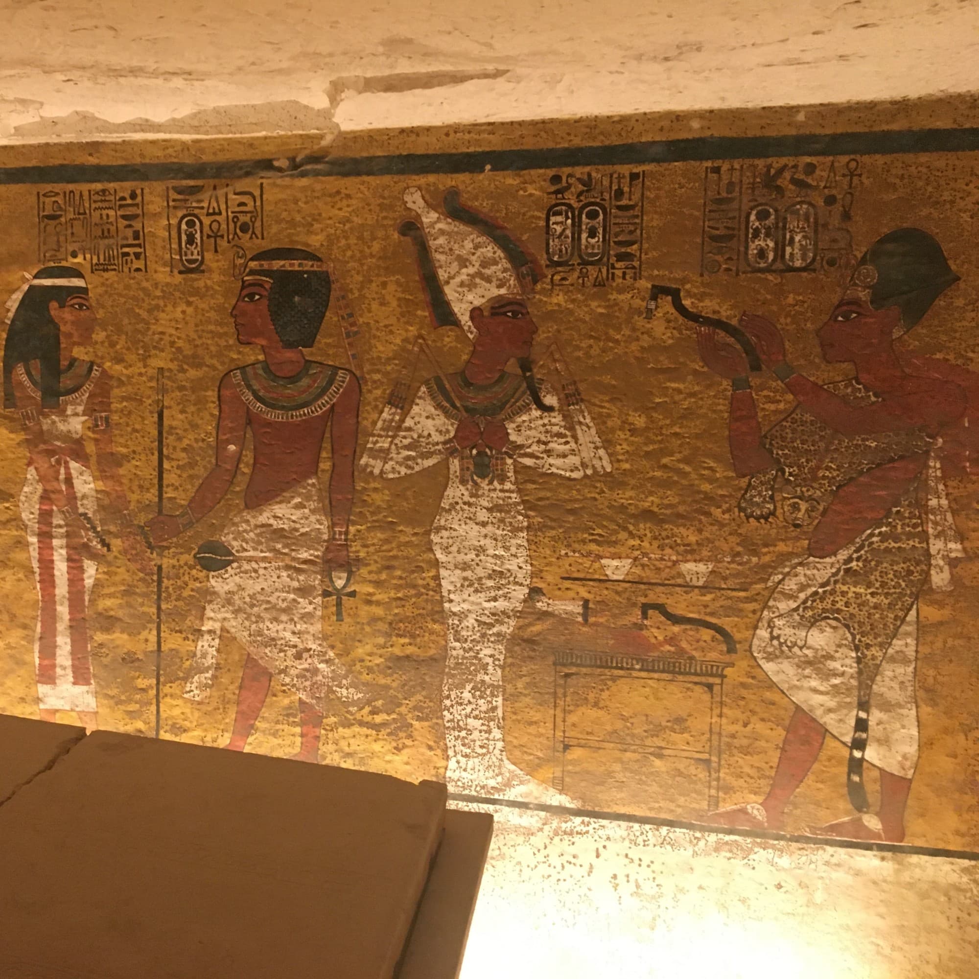 An ancient Egyptian wall painting with hieroglyphics and figures in traditional attire, showcasing cultural and historical significance.