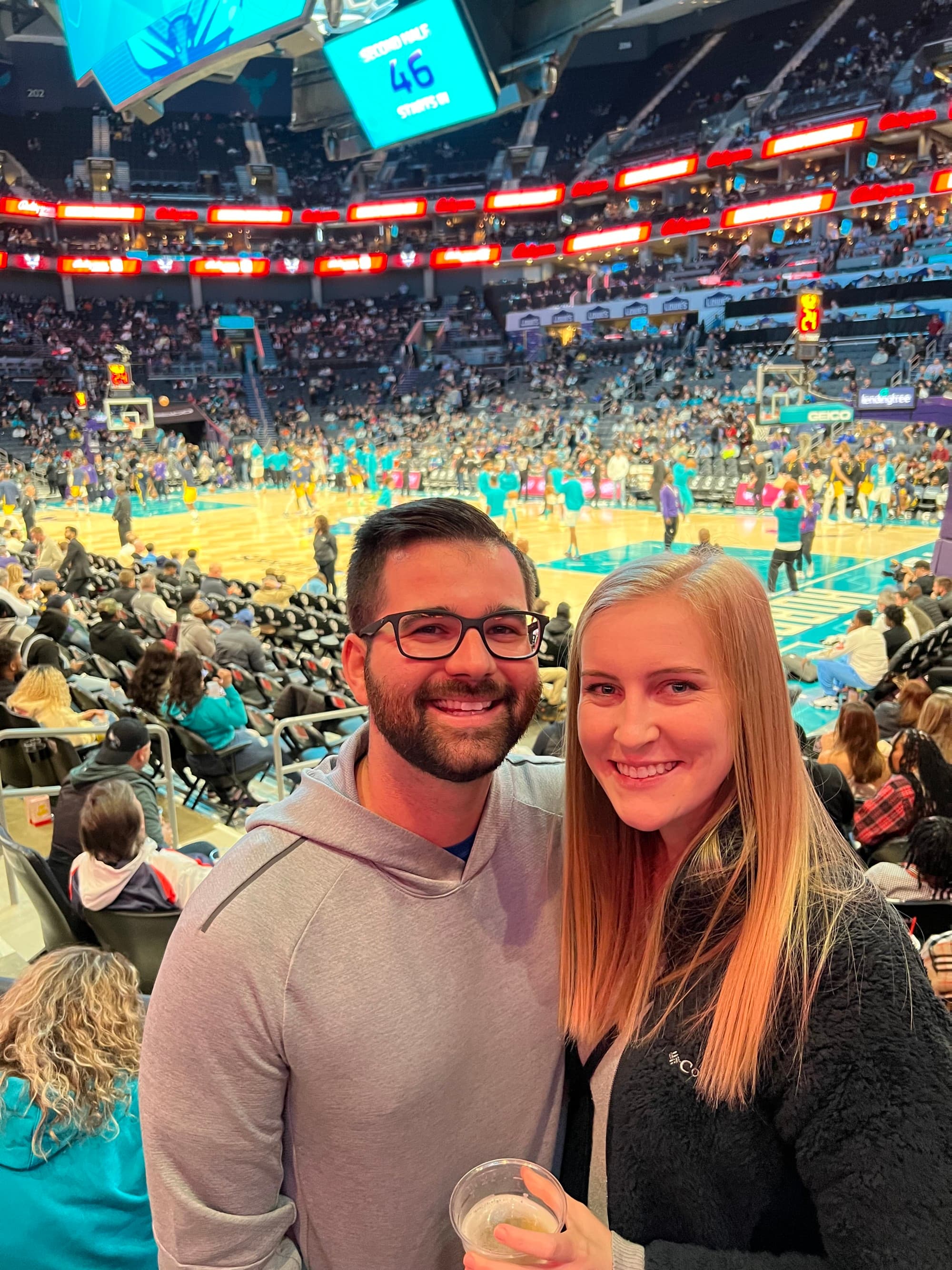 Couple with basket ball game at back.