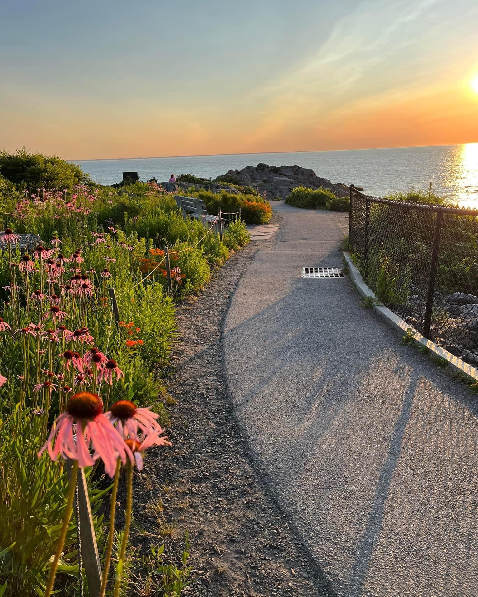 A walkway by the water during a sunset