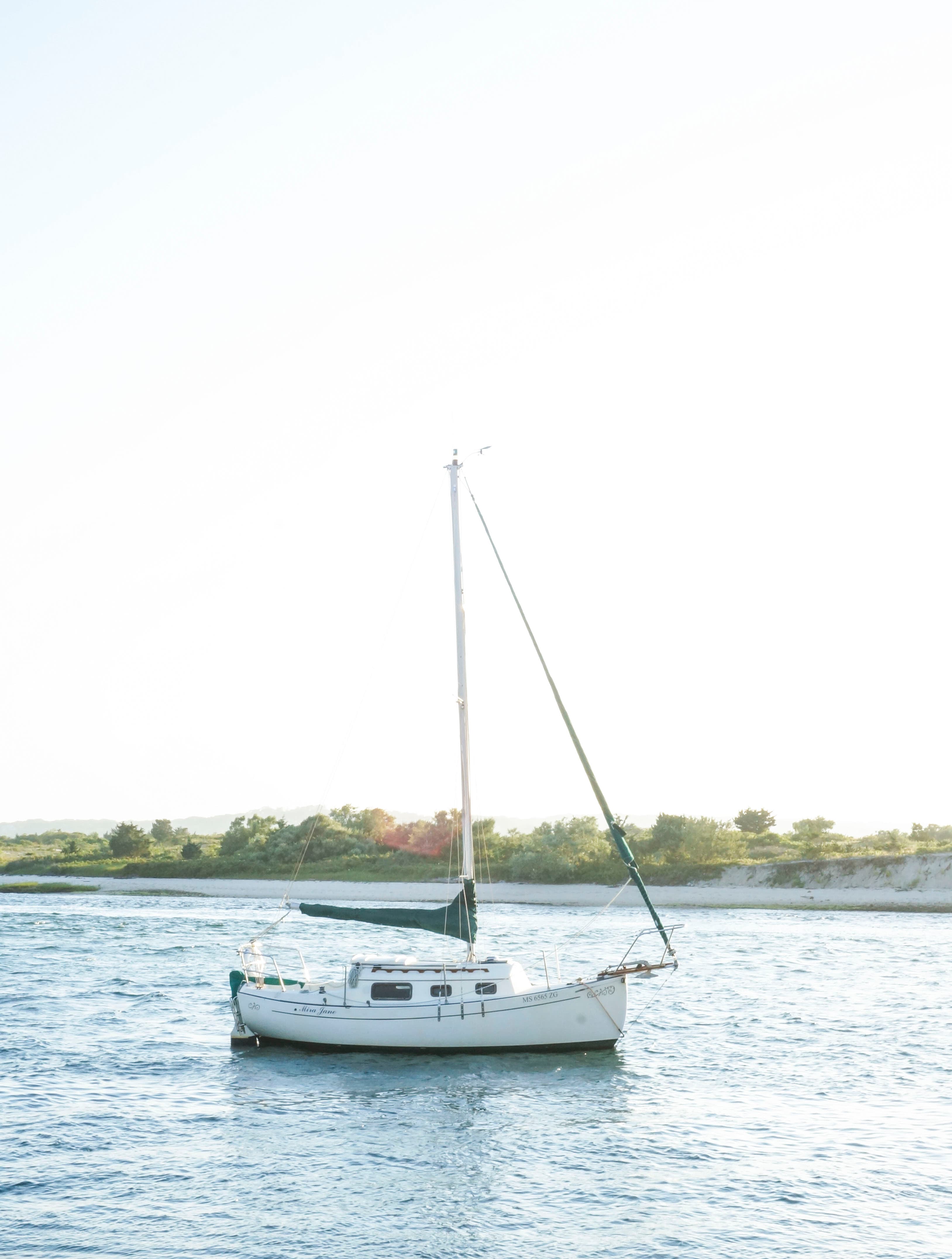 A boat at sea as the waves gently lap the shore on a sunny day.