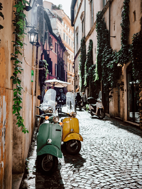 Two bikes in a narrow road between buildings during the daytime