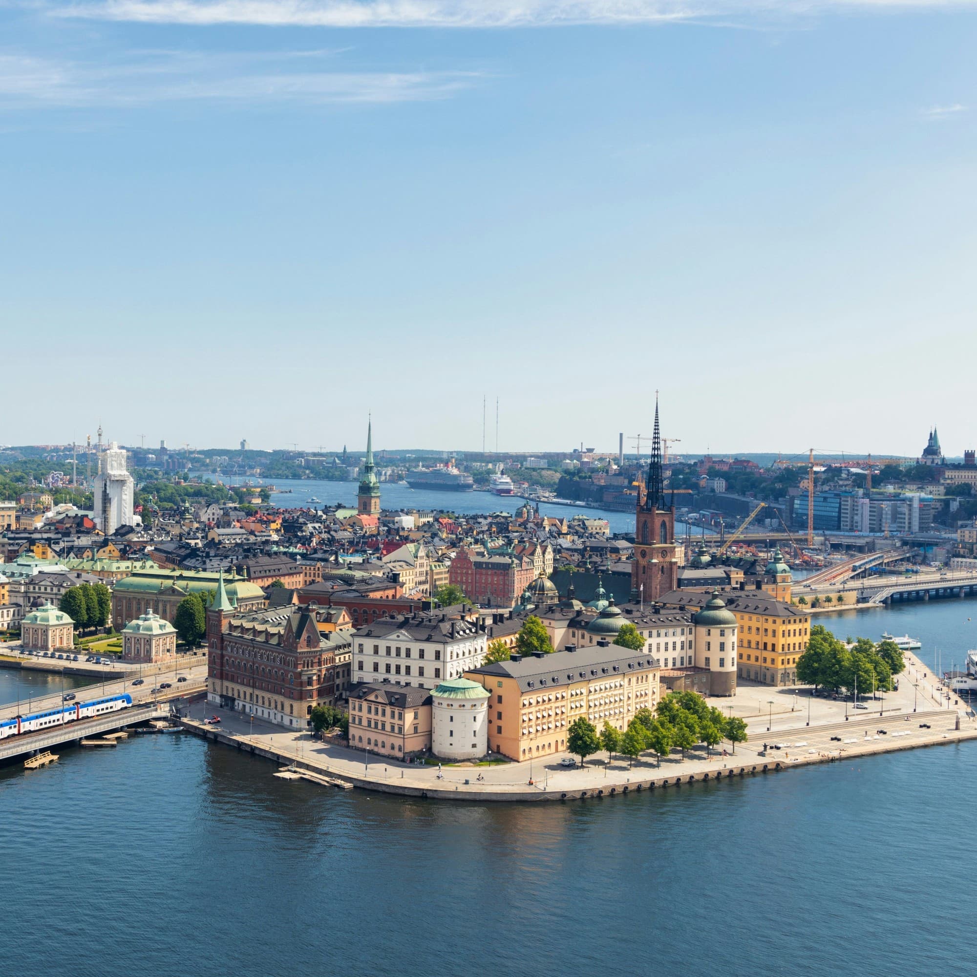 An aerial view of a historic city with waterways and bridges under a clear sky.