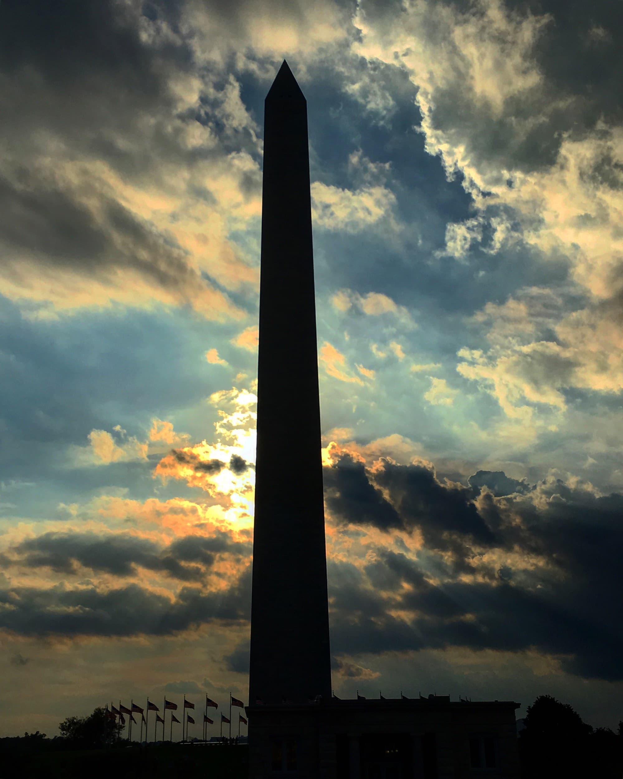 Silhouette of a tall tower against a sunset sky