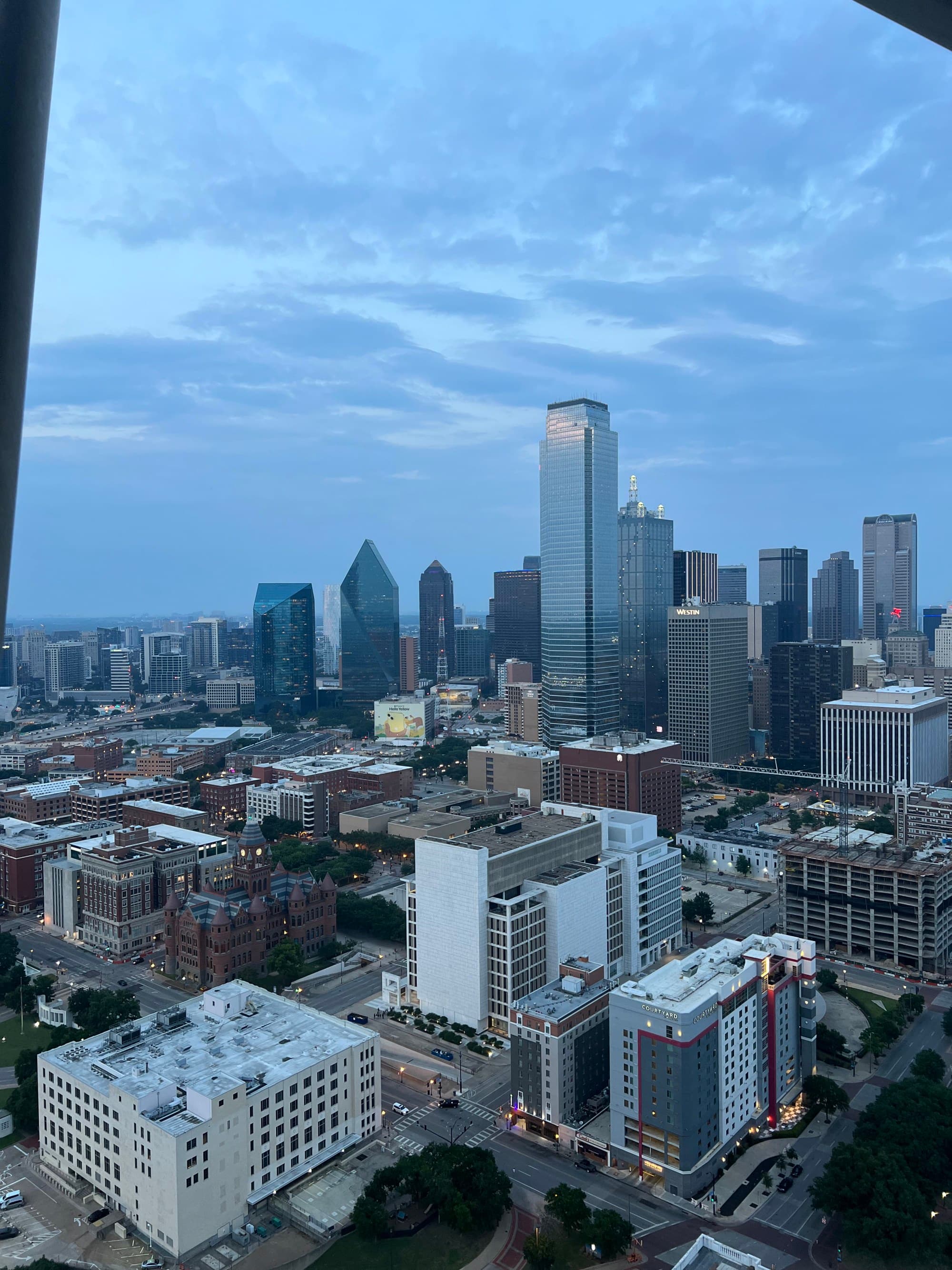 City skyline from a window under a cloudy sky.