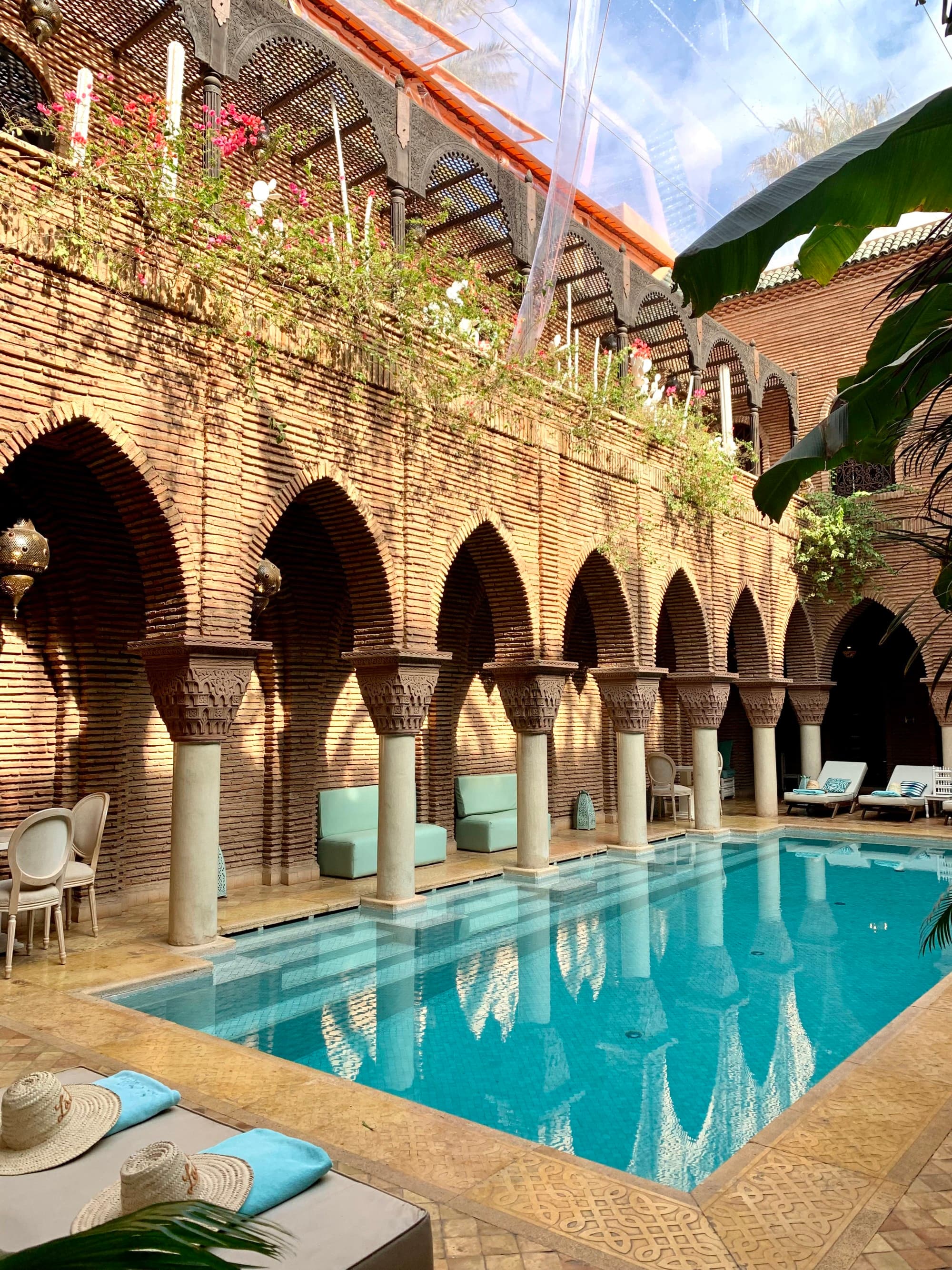 An outside swimming pool area surrounded by brick columns