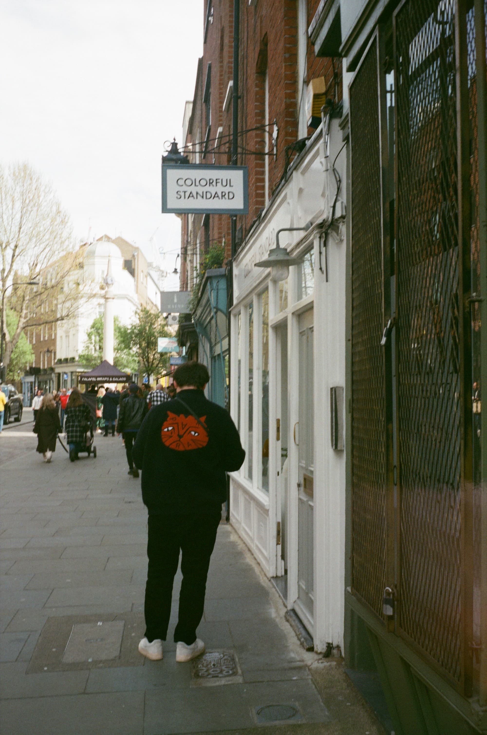 A person walking in the street next to buildings during the daytime