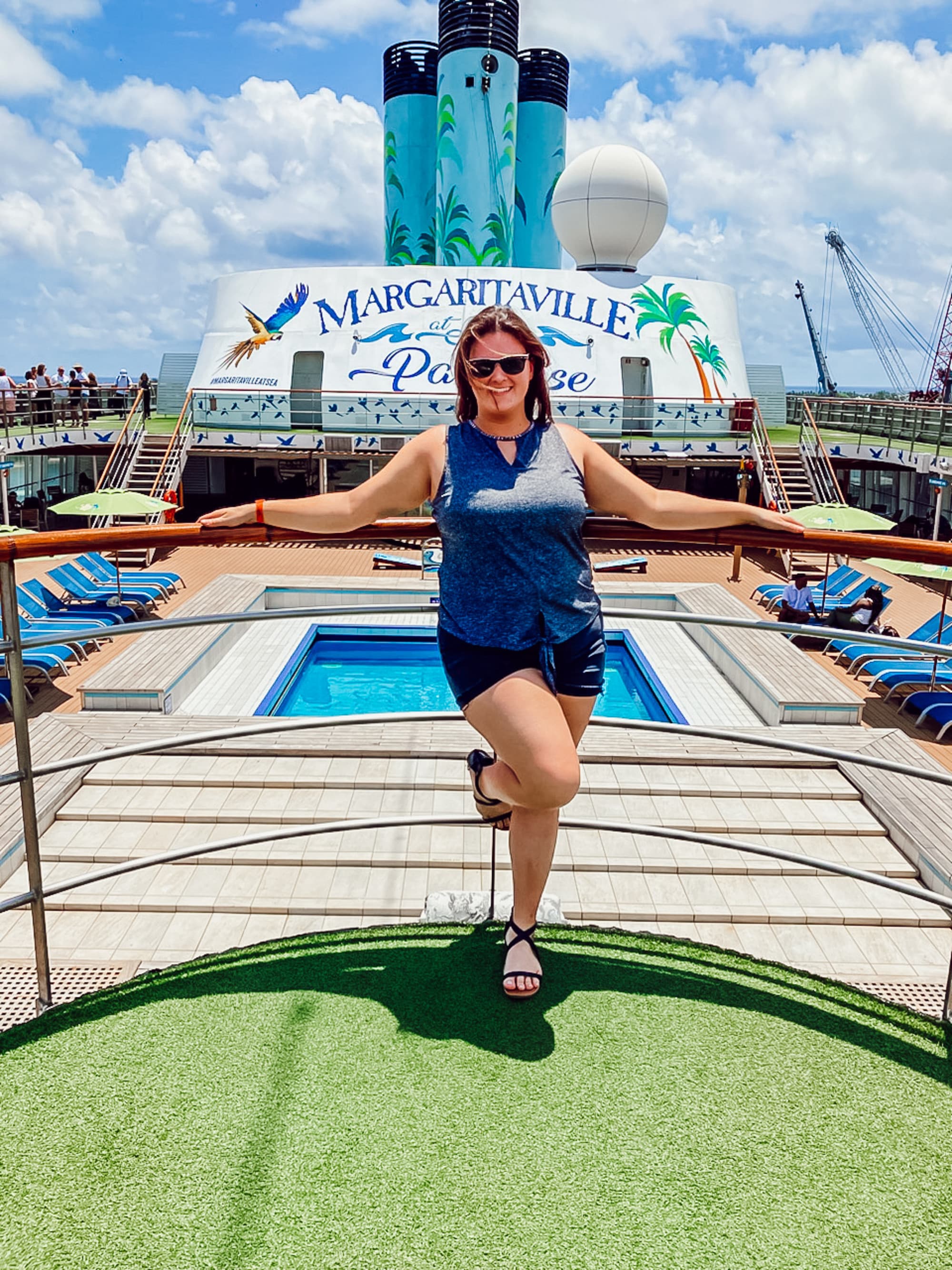 A girl posing in blue dress on a sea deck.