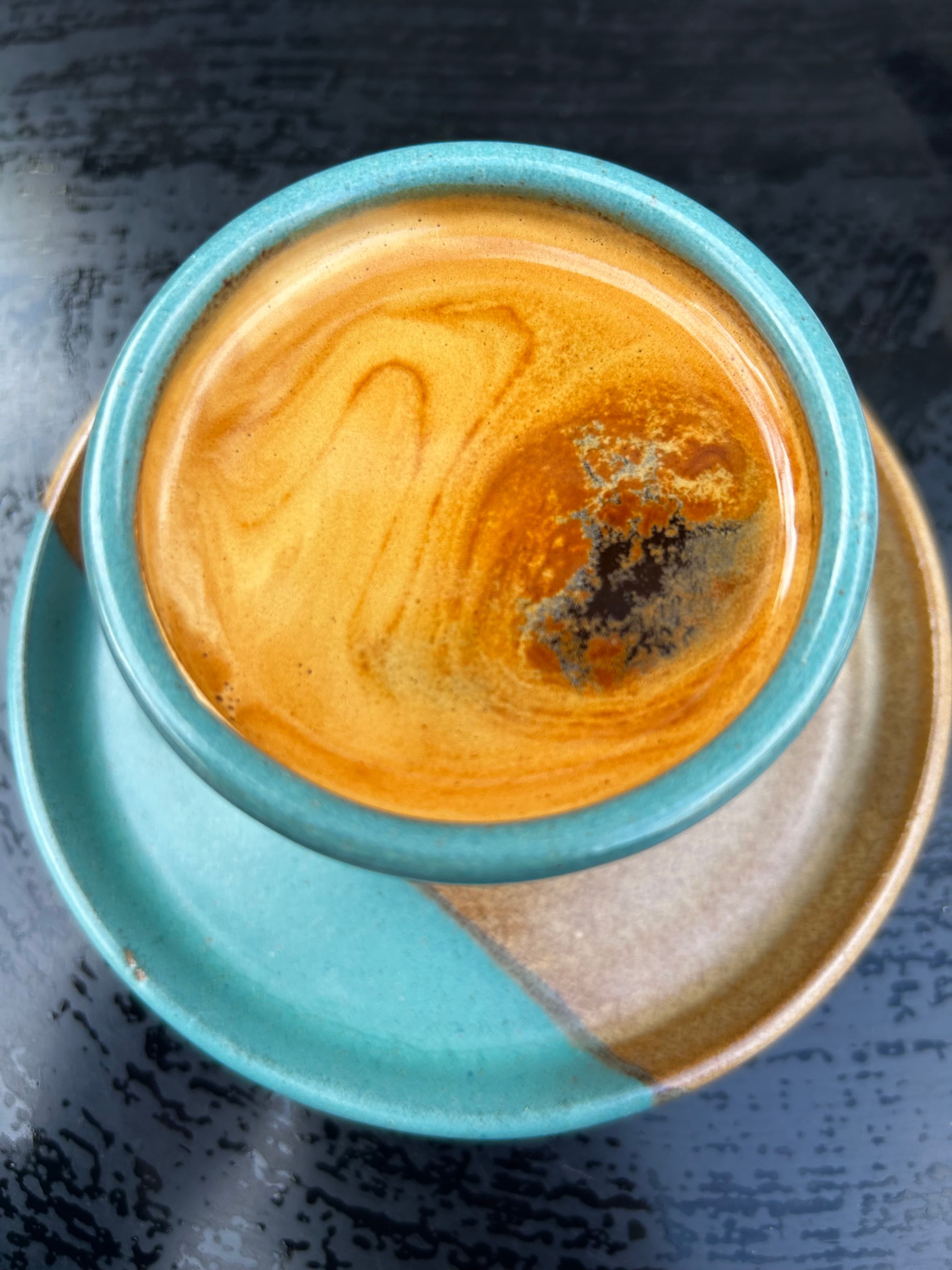 Black coffee with ice and milk on a table.