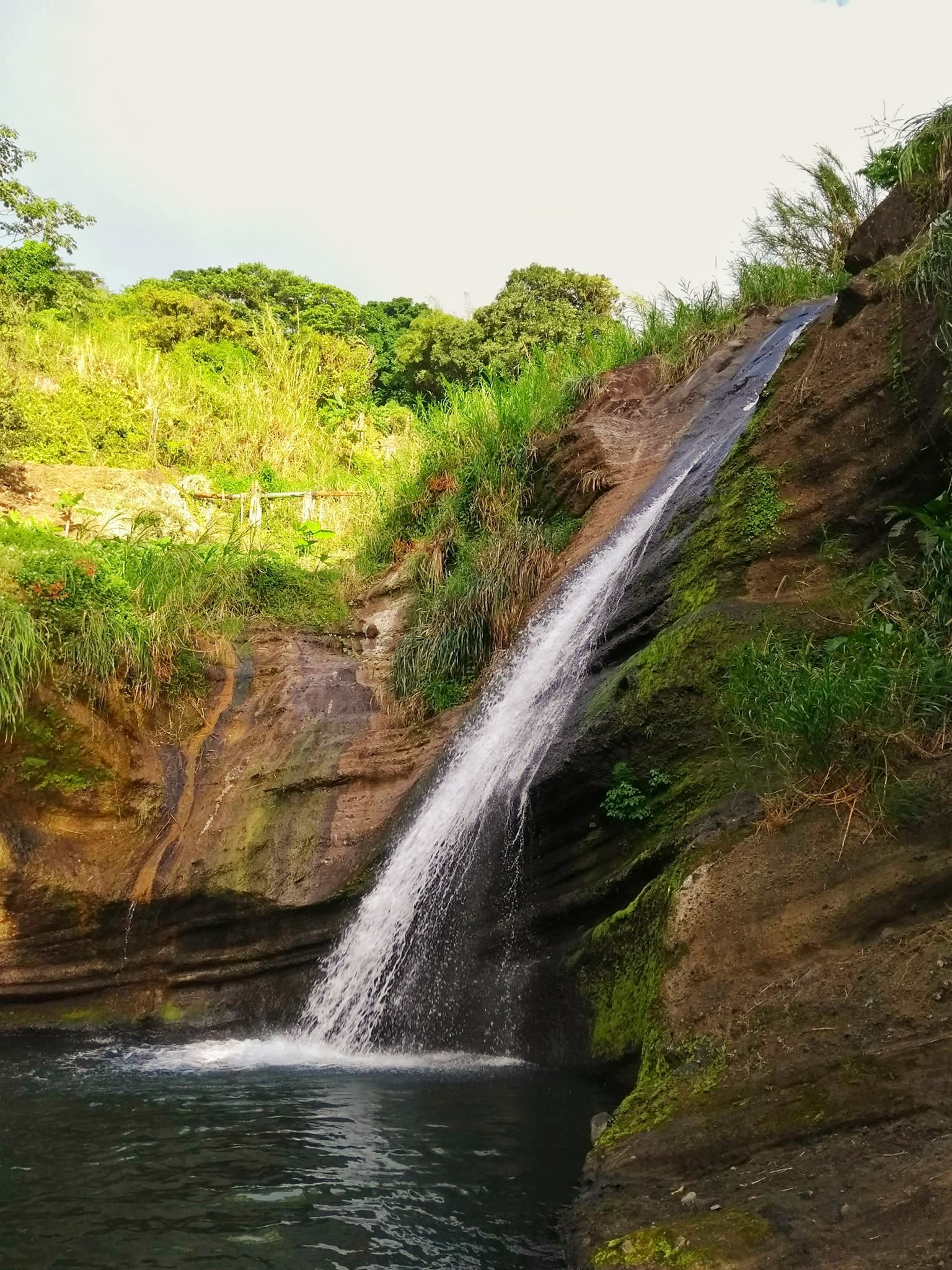 A small stream waterfall rushing down a cliff.