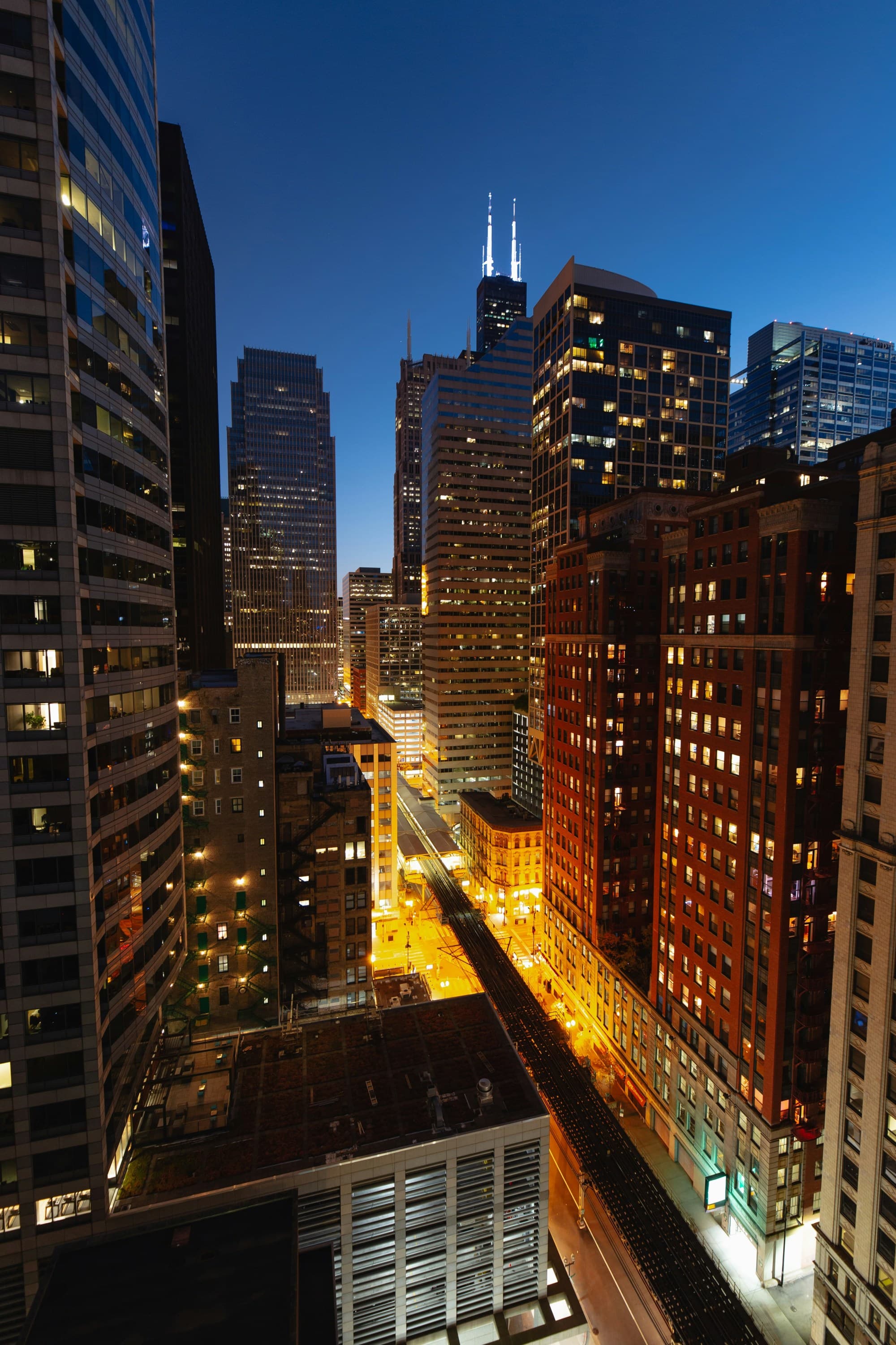 The image depicts a night scene of a bustling city with illuminated skyscrapers and streets.