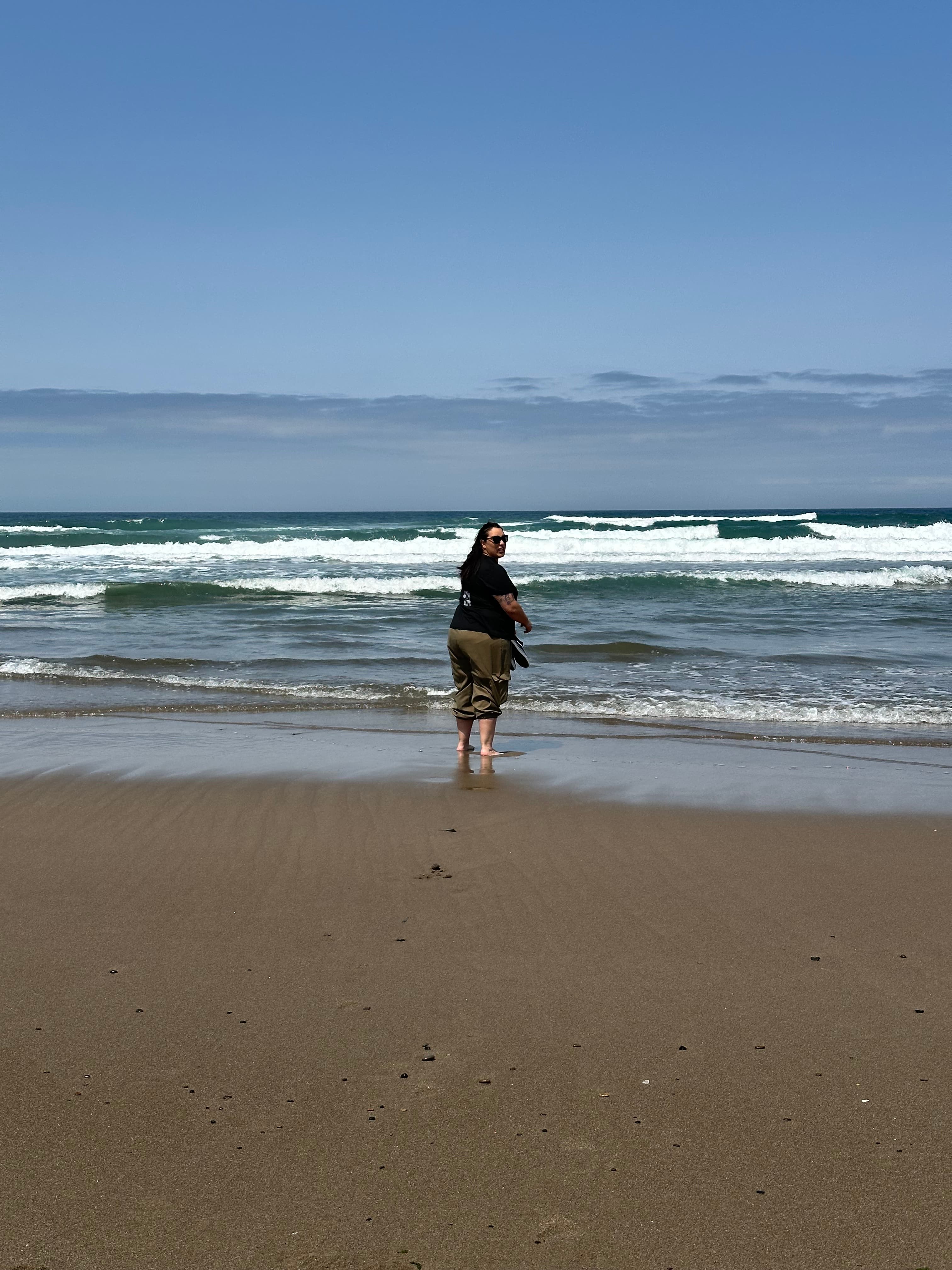 Woman on a beach with small surf.