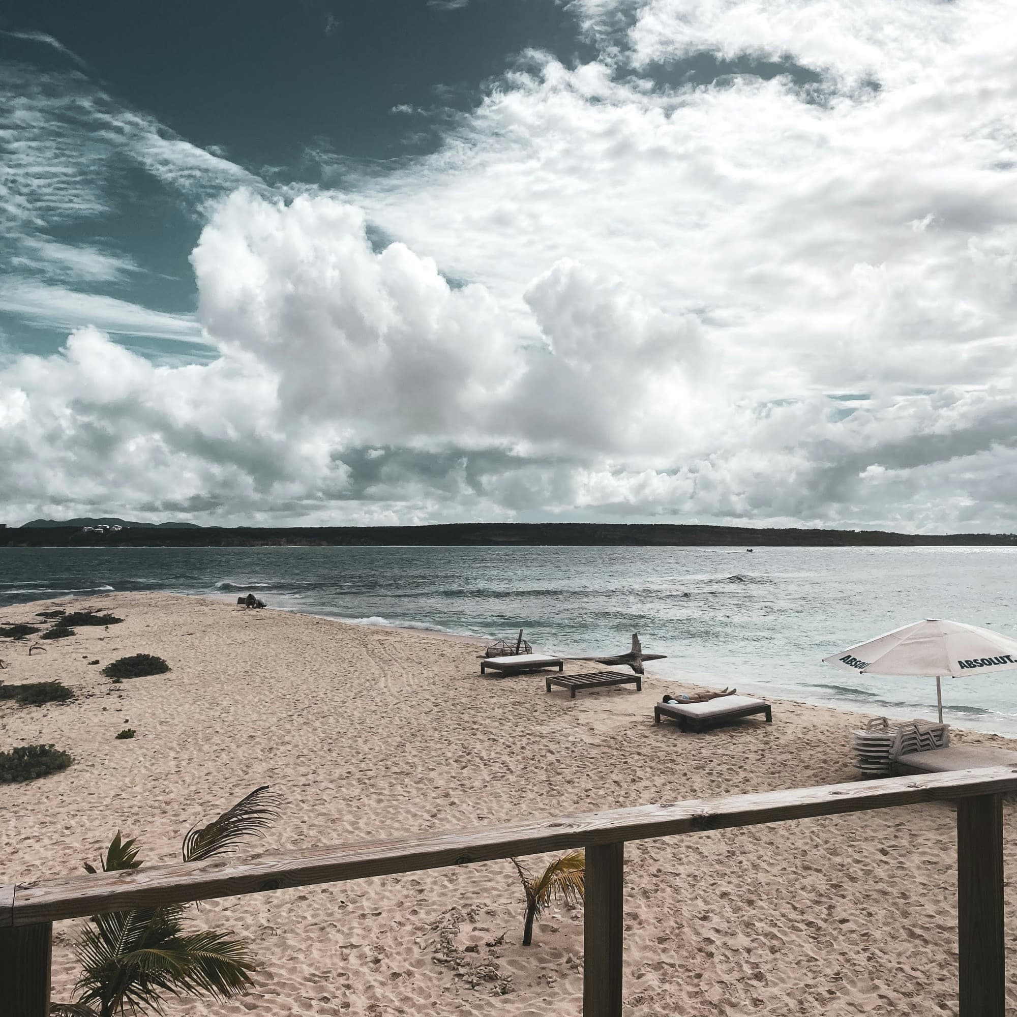 Beach chairs on beach on a partly cloudy day.